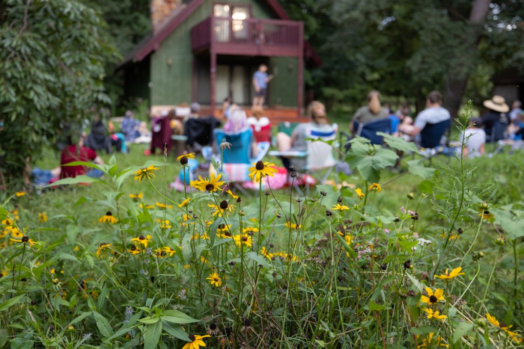 A shot from the back of the crowd, showing black-eyed susans and people in lawn chairs. 