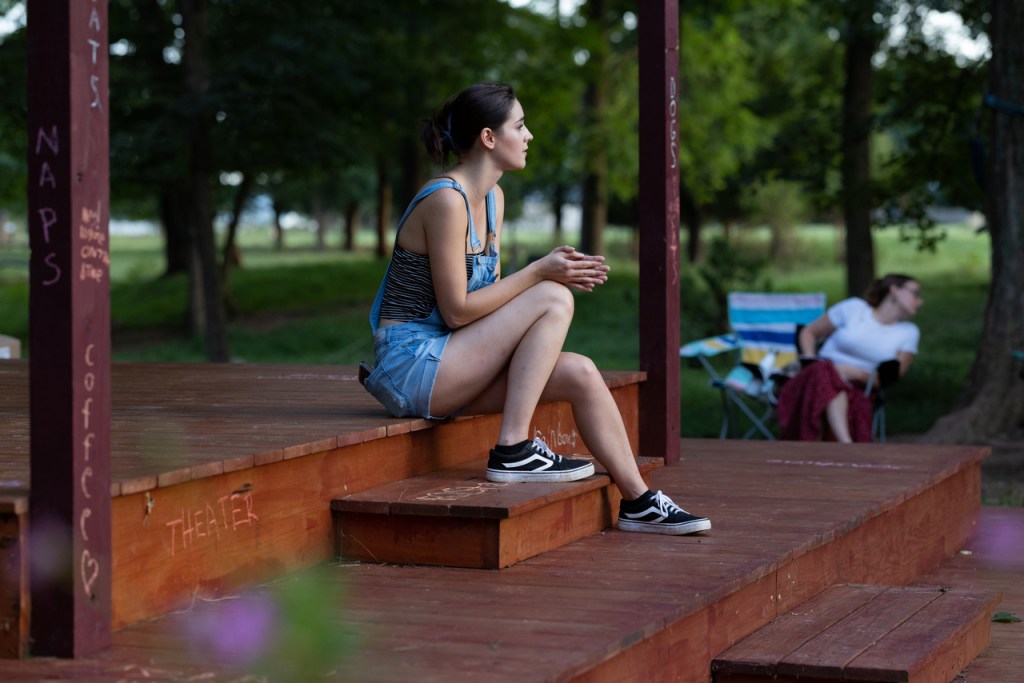 Katie sits on stage.
