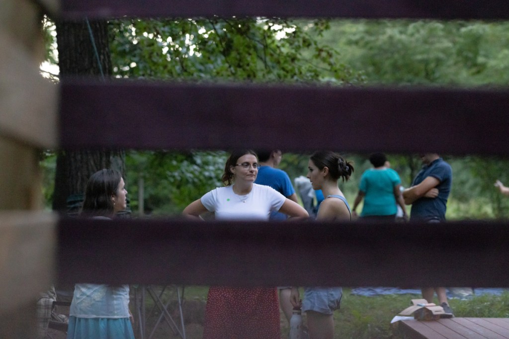 Aili, Katie, and MaryBeth chat after the show. This photo was shot through a railing, which is blurry in the foreground.
